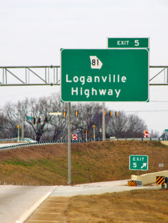 a green sign on a highway