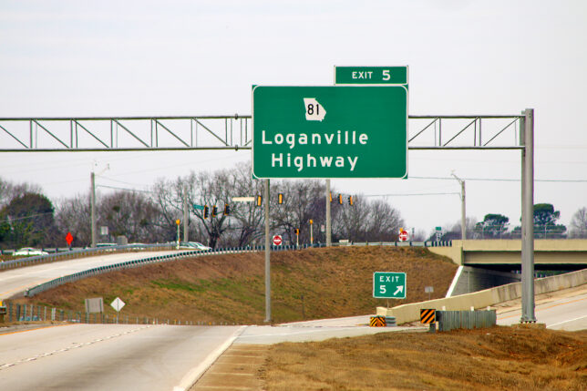 a green sign on a highway