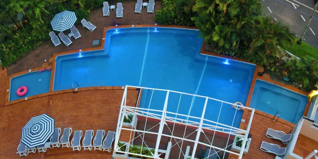 a pool with lounge chairs and trees