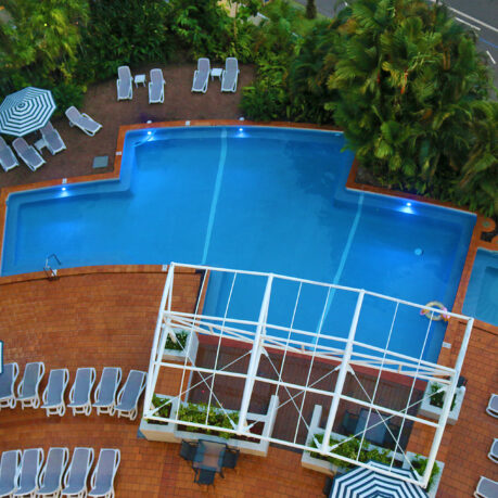 a pool with lounge chairs and trees