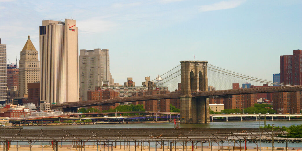 a bridge over water with a city in the background