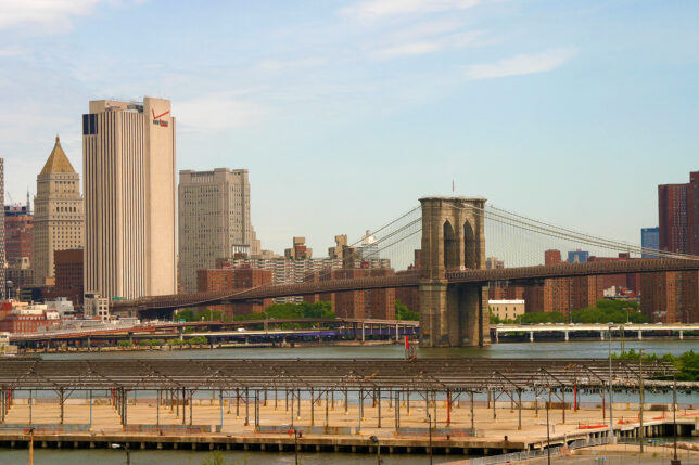 a bridge over water with a city in the background