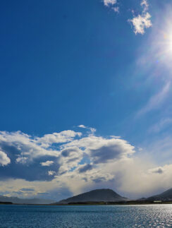a body of water with mountains in the background