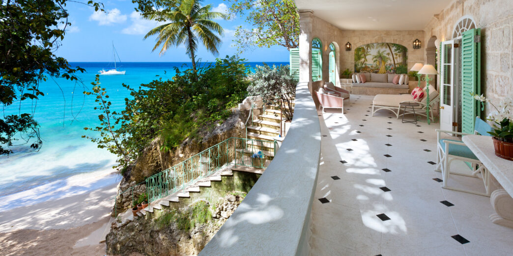 a large white building with a beach and a blue ocean