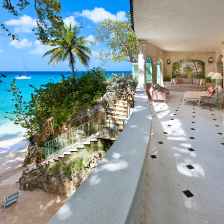 a large white building with a beach and a blue ocean