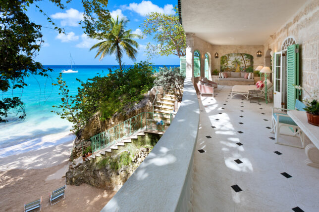 a large white building with a beach and a blue ocean