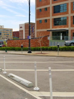 a street with white poles and cars parked on the side