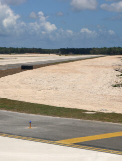 a runway with a road and trees