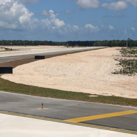 a runway with a road and trees