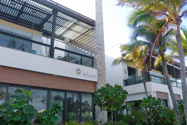 a building with palm trees and a roof