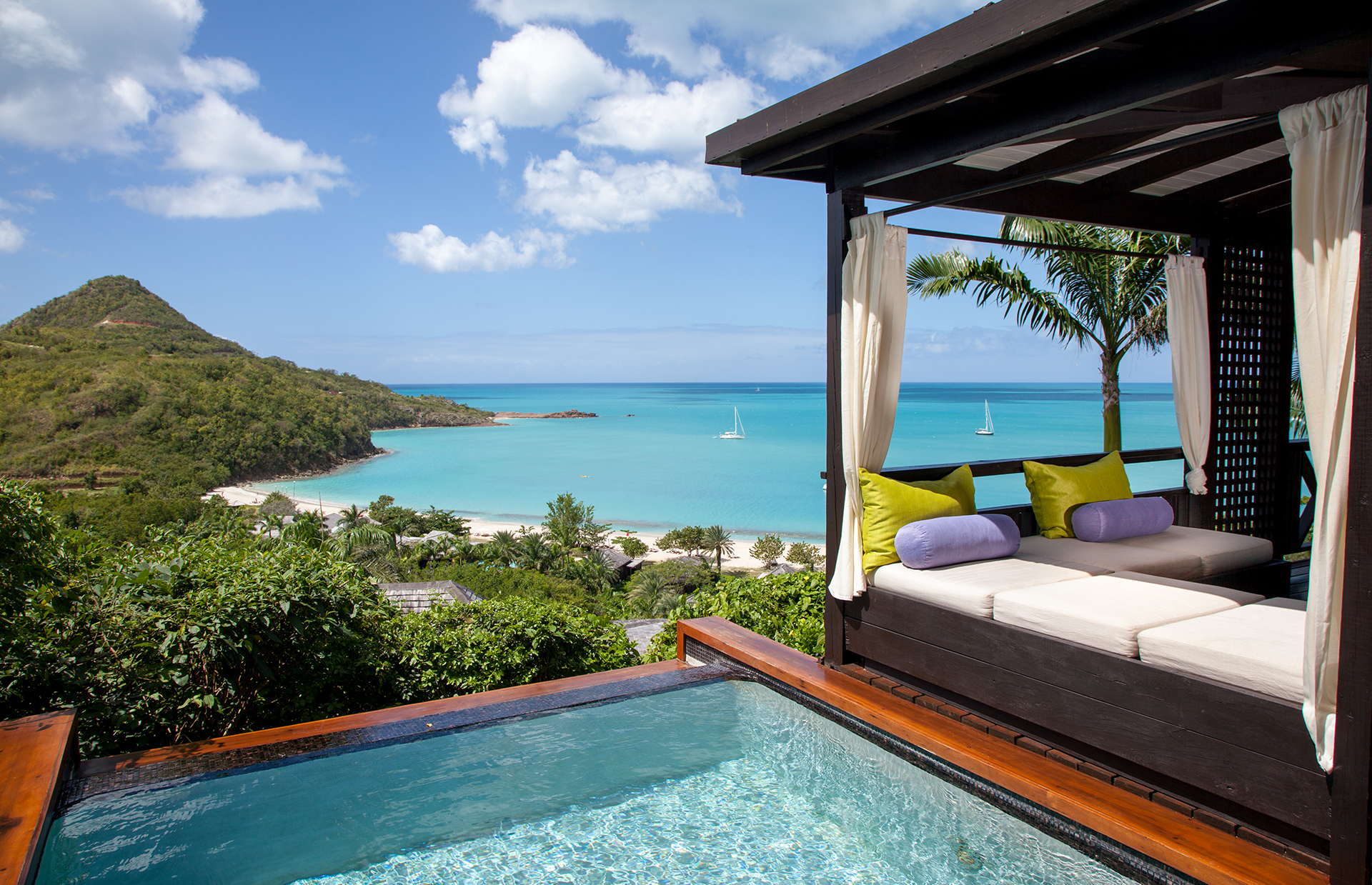 a pool with a bed and a beach in the background