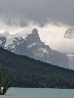a lake with trees and mountains in the background