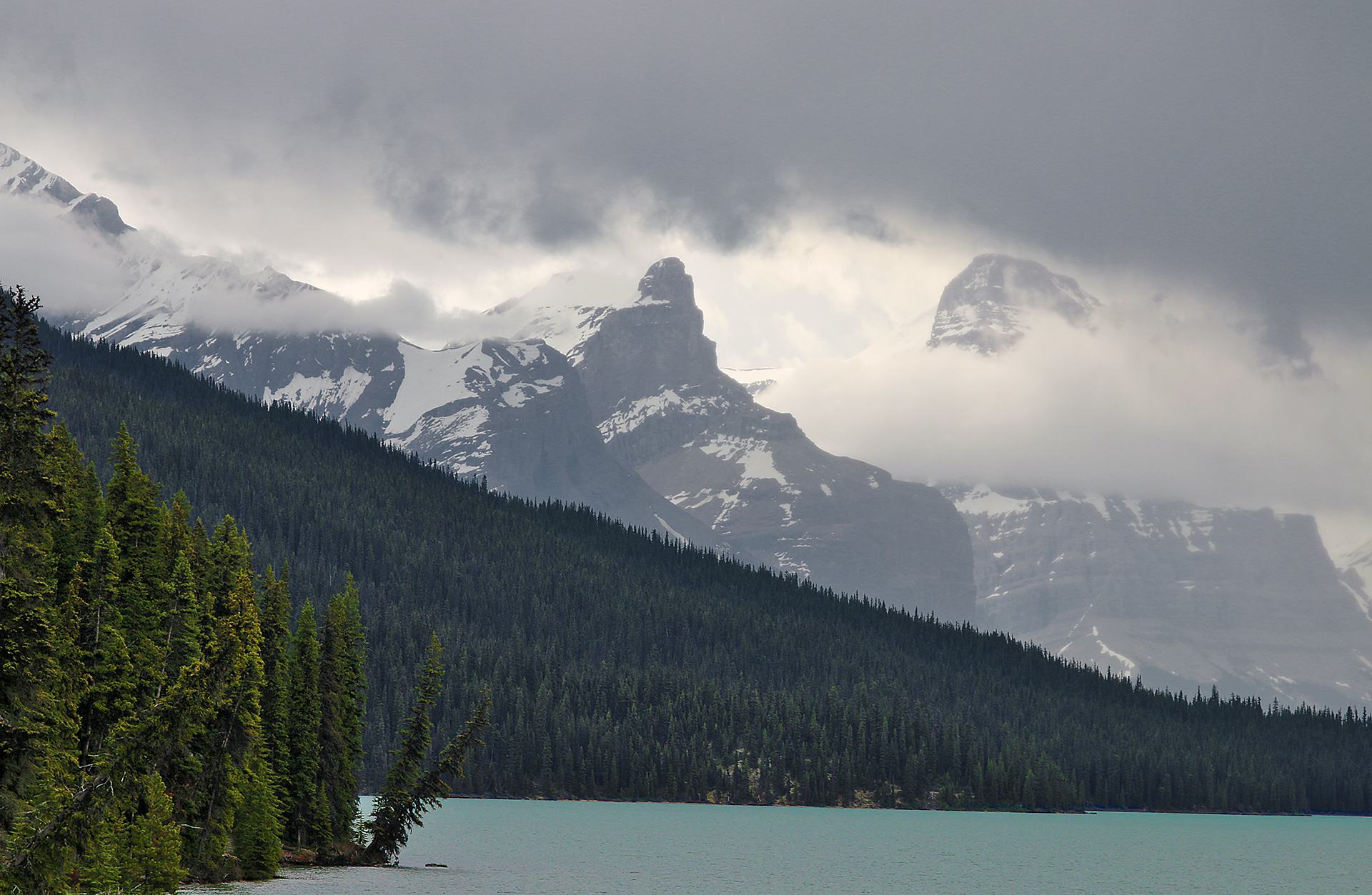 a lake with trees and mountains in the background