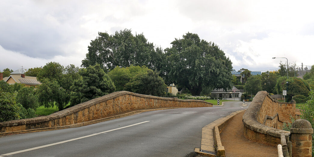 a road with a bridge and trees