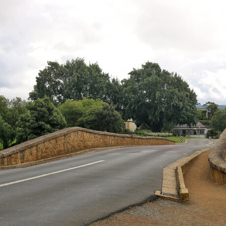 a road with a bridge and trees