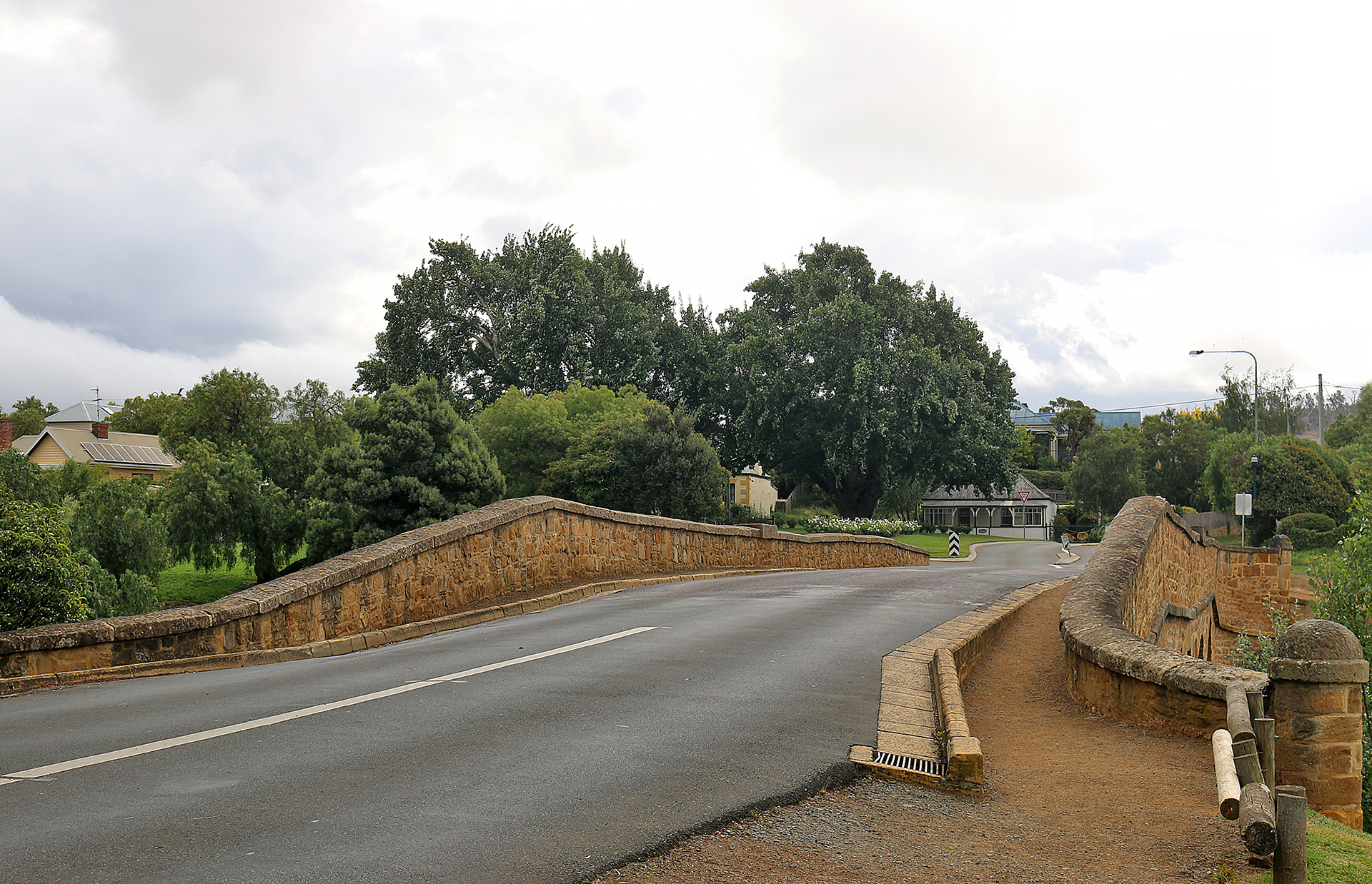 a road with a bridge and trees