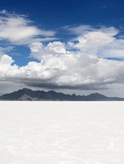 a chair in the middle of a flat white desert