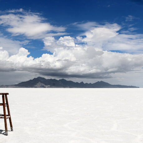 a chair in the middle of a flat white desert