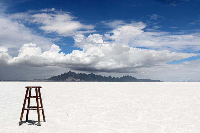 a chair in the middle of a flat white desert