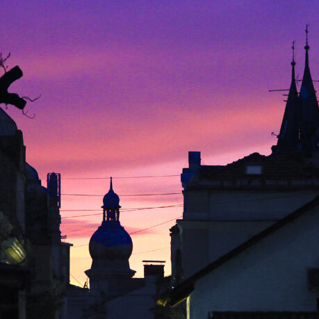 a silhouette of a building with a dome and a purple sky