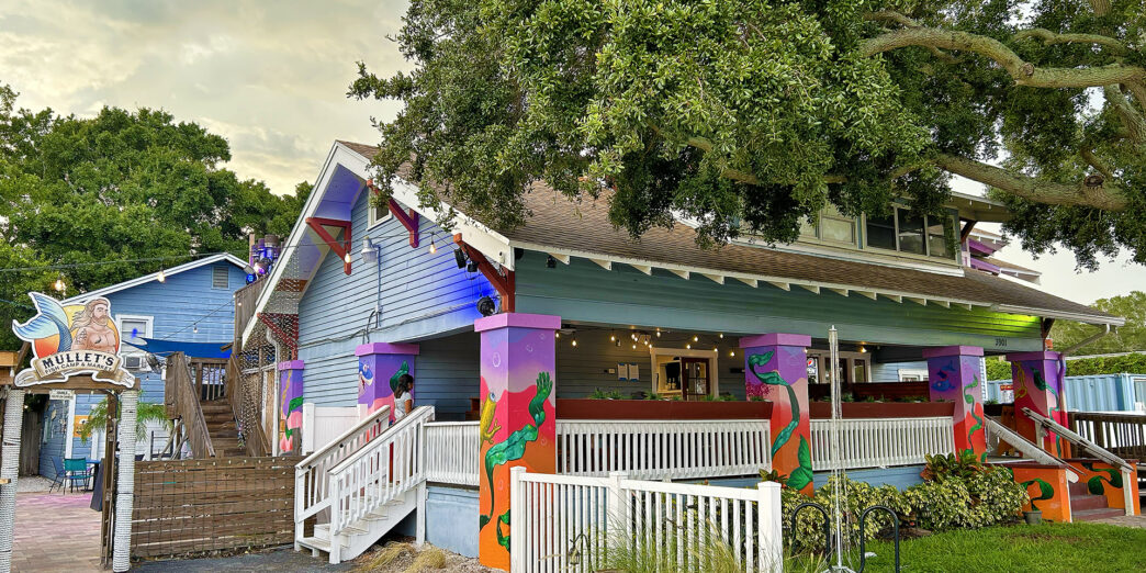a house with a white railing and a tree