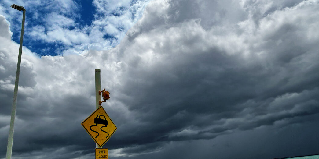 a sign on a pole near water