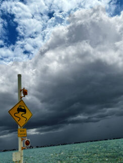 a sign on a pole near water