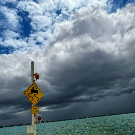a sign on a pole near water