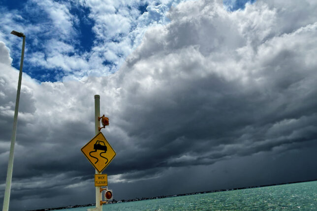 a sign on a pole near water