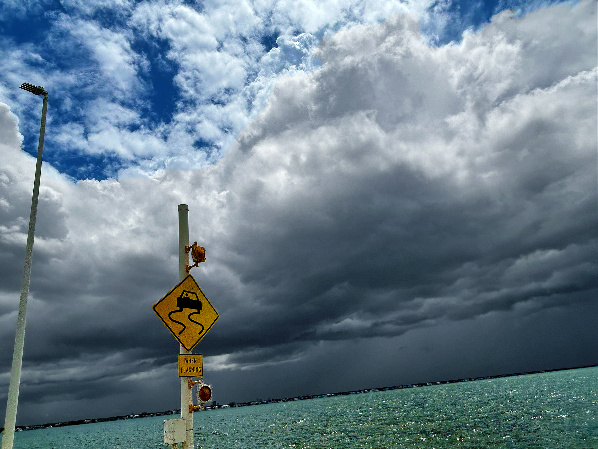 a sign on a pole near water