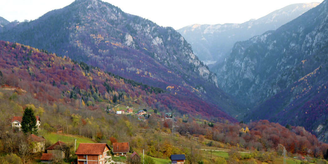 a house on a hill with mountains in the background