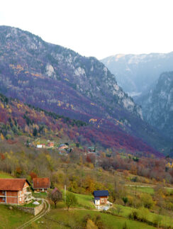 a house on a hill with mountains in the background