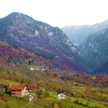 a house on a hill with mountains in the background