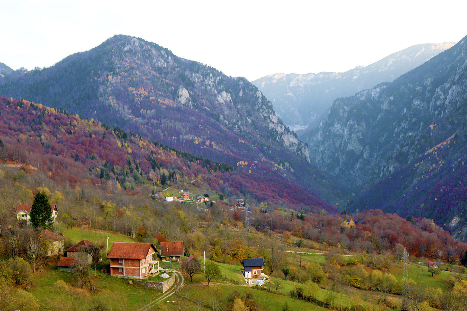 a house on a hill with mountains in the background