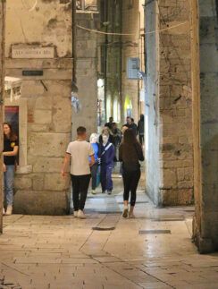 people walking through a stone building