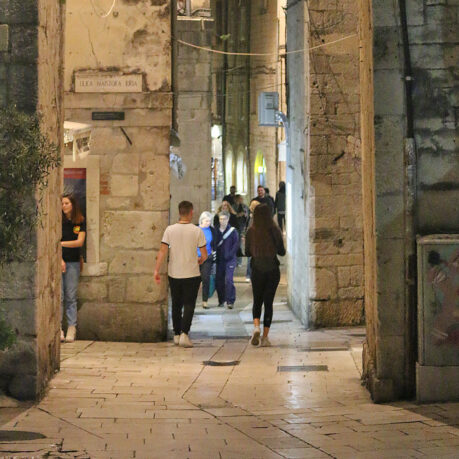 people walking through a stone building