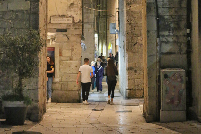 people walking through a stone building