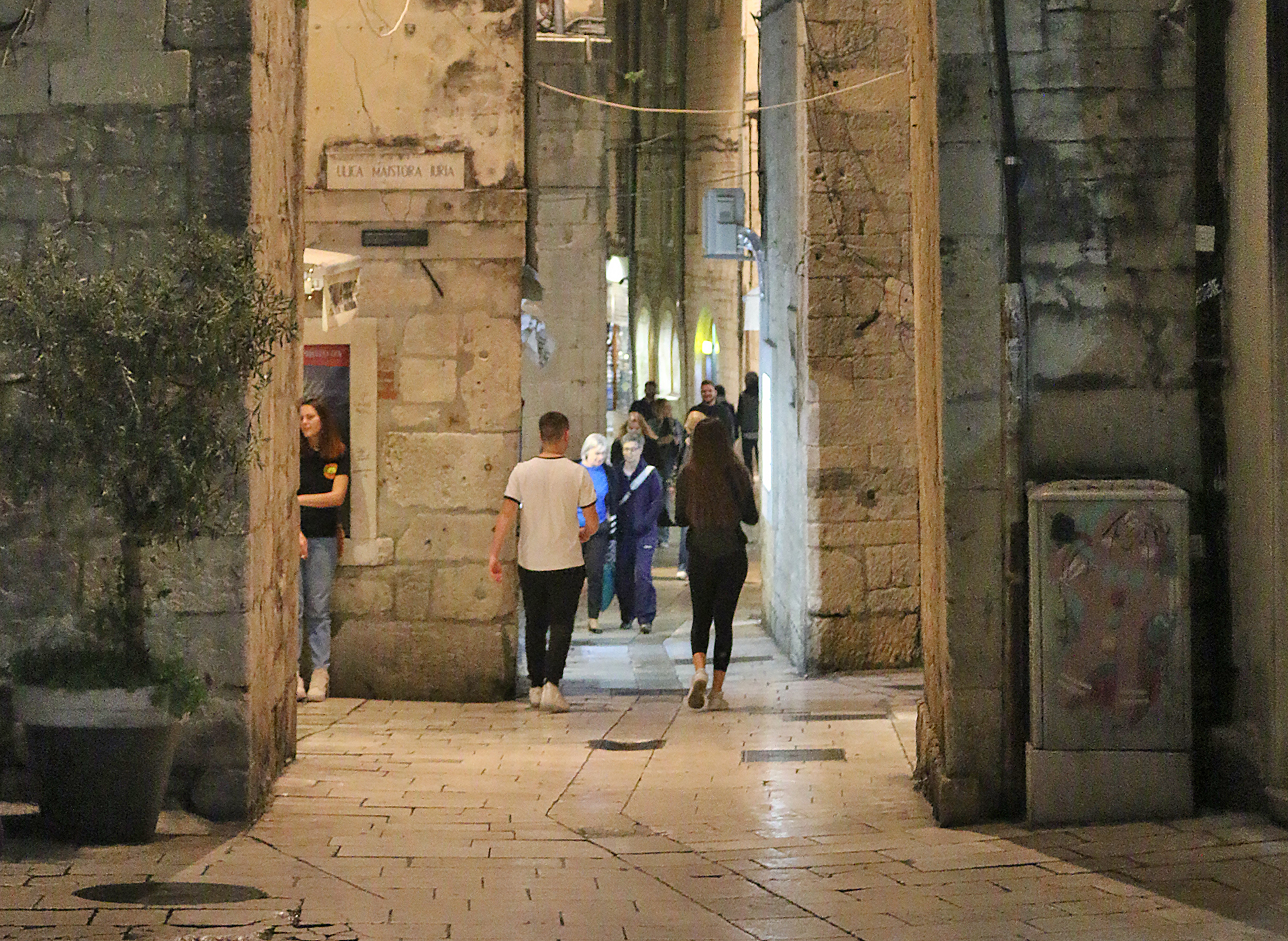 people walking through a stone building