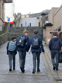 a group of boys walking down a path with backpacks