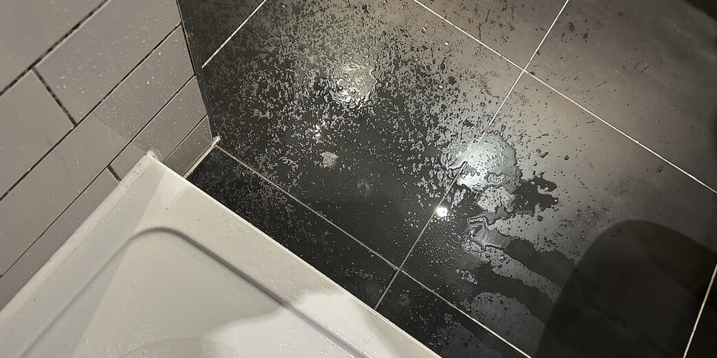 a black tile floor with water on it
