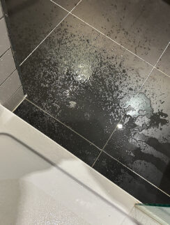 a black tile floor with water on it