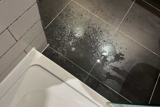 a black tile floor with water on it
