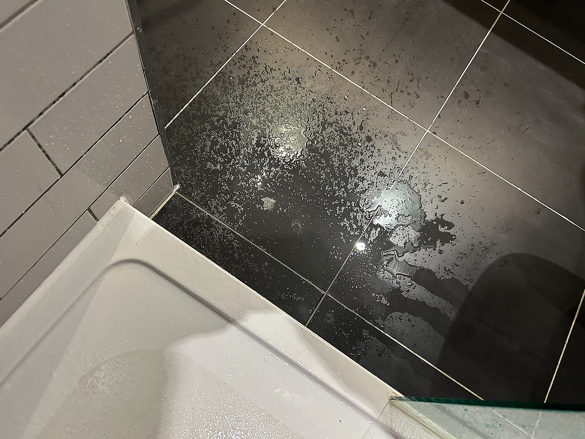 a black tile floor with water on it