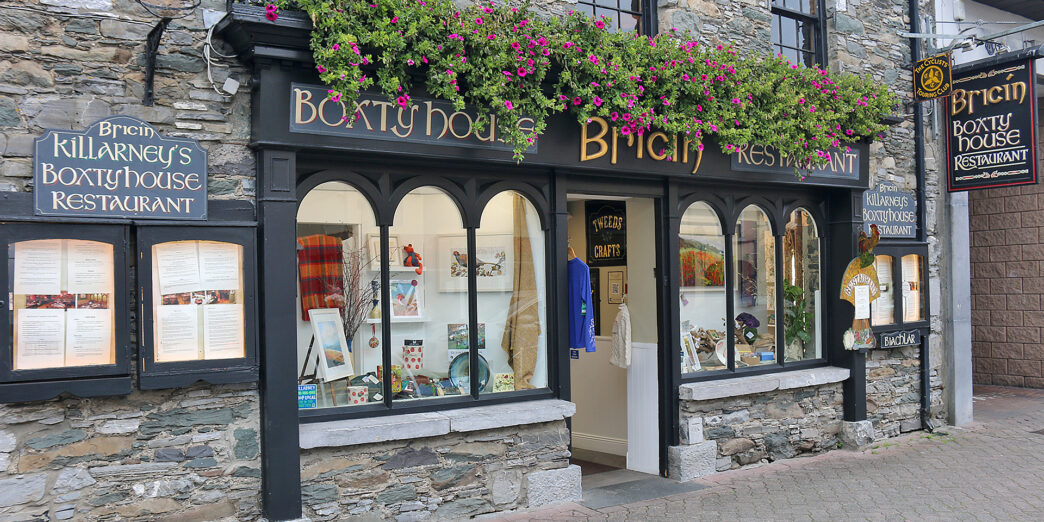 a store front with flowers on the windows