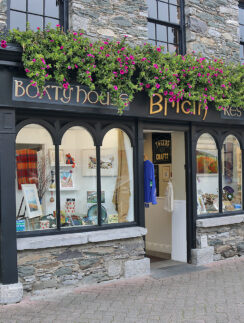 a store front with flowers on the windows