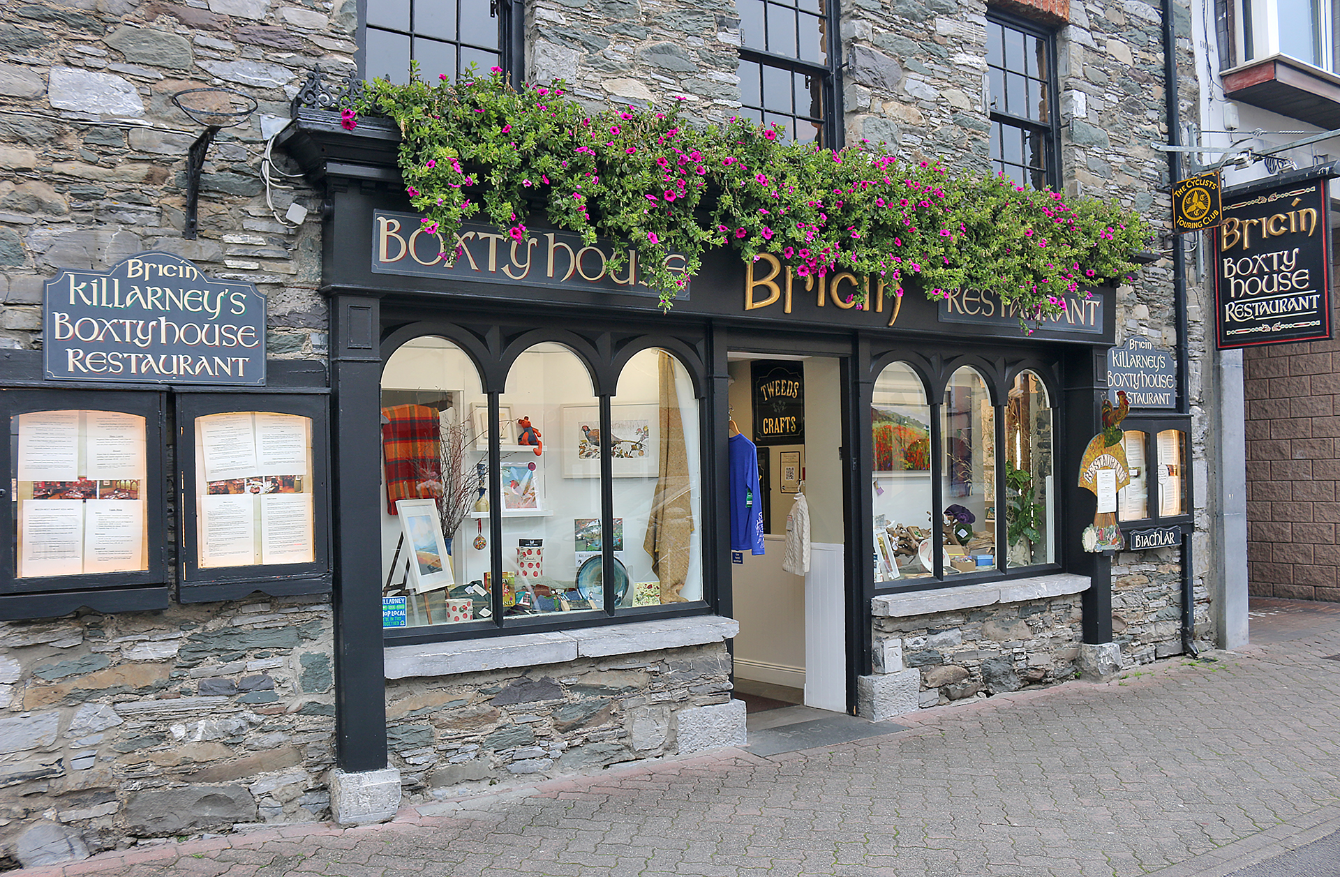 a store front with flowers on the windows