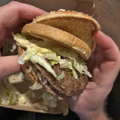 a person holding a burger