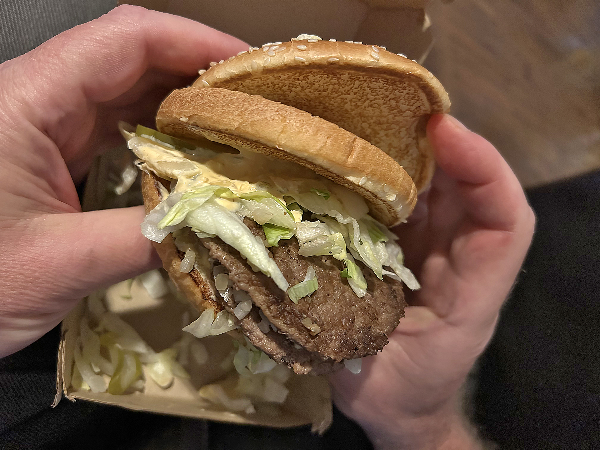 a person holding a burger