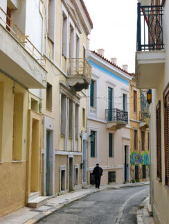 a person walking down a street with buildings