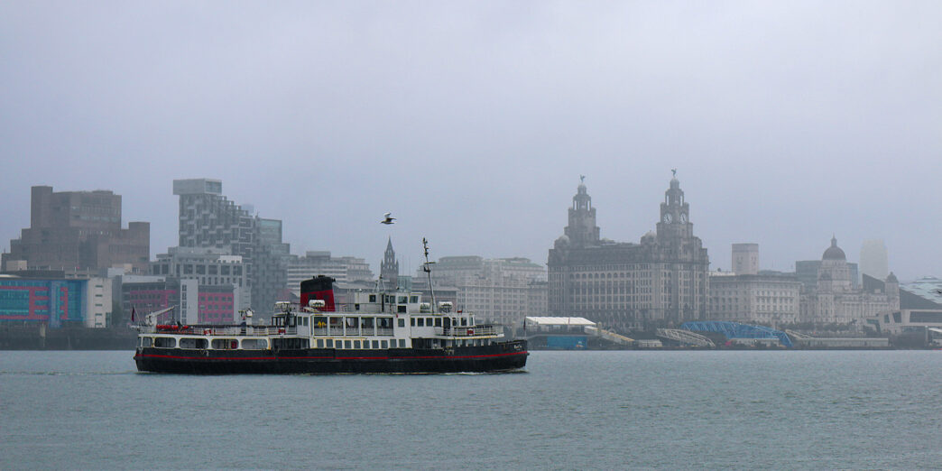 a boat in the water with a city in the background